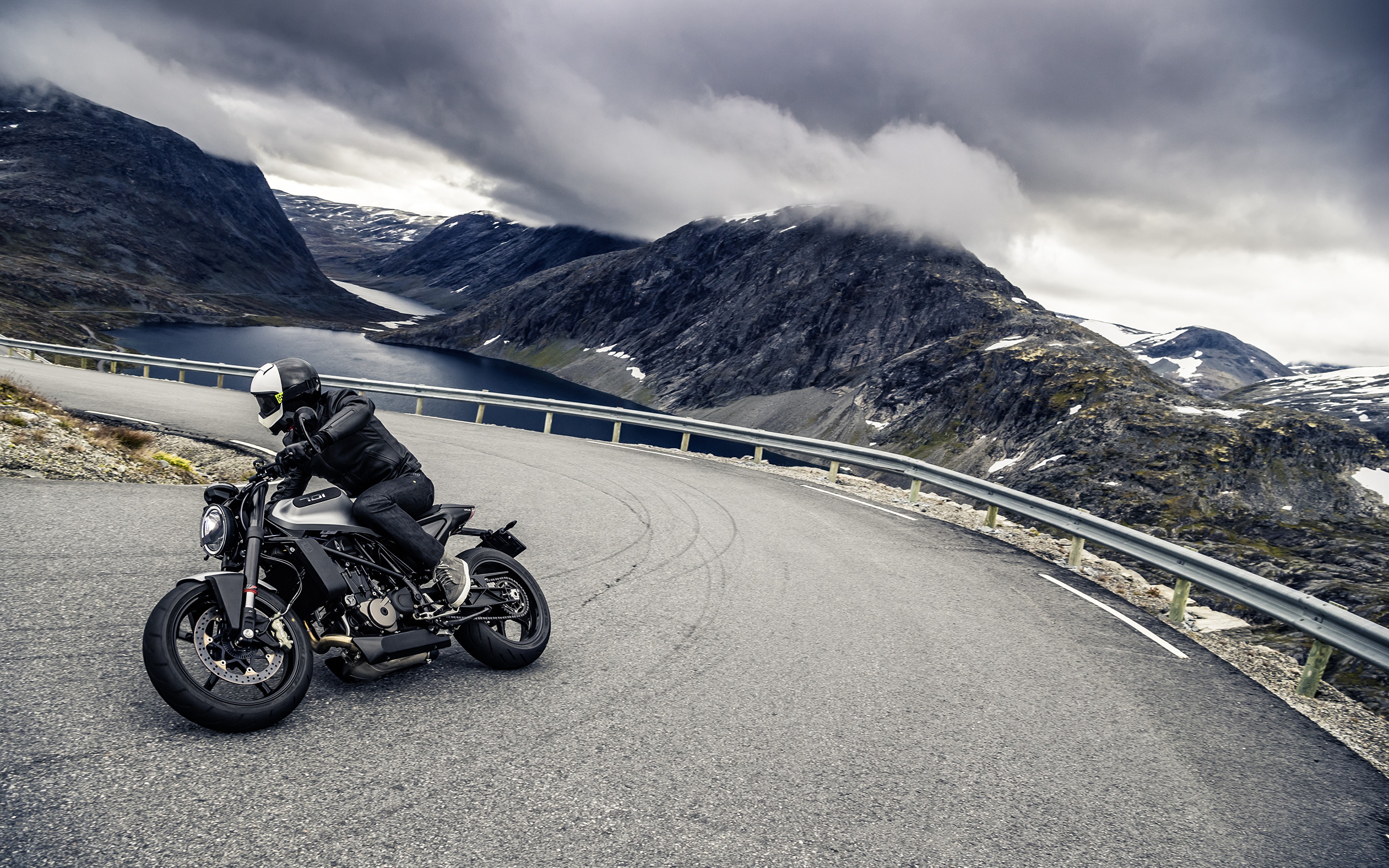 Foto Hombre con casco negro montando en bicicleta de montaña negra en la  carretera durante el día …