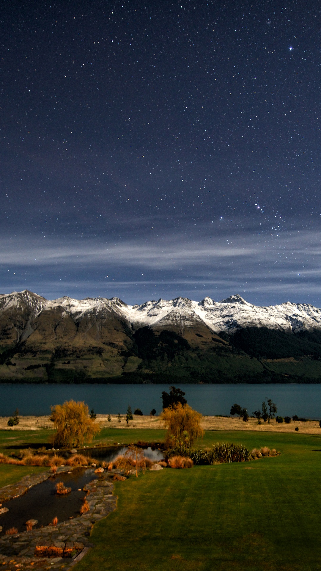 Green Grass Field Near Snow Covered Mountain During Night Time. Wallpaper in 1080x1920 Resolution