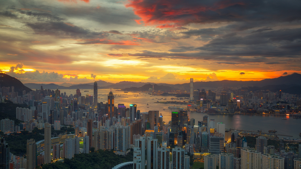 City Skyline Under Orange and Gray Cloudy Sky During Sunset. Wallpaper in 1280x720 Resolution