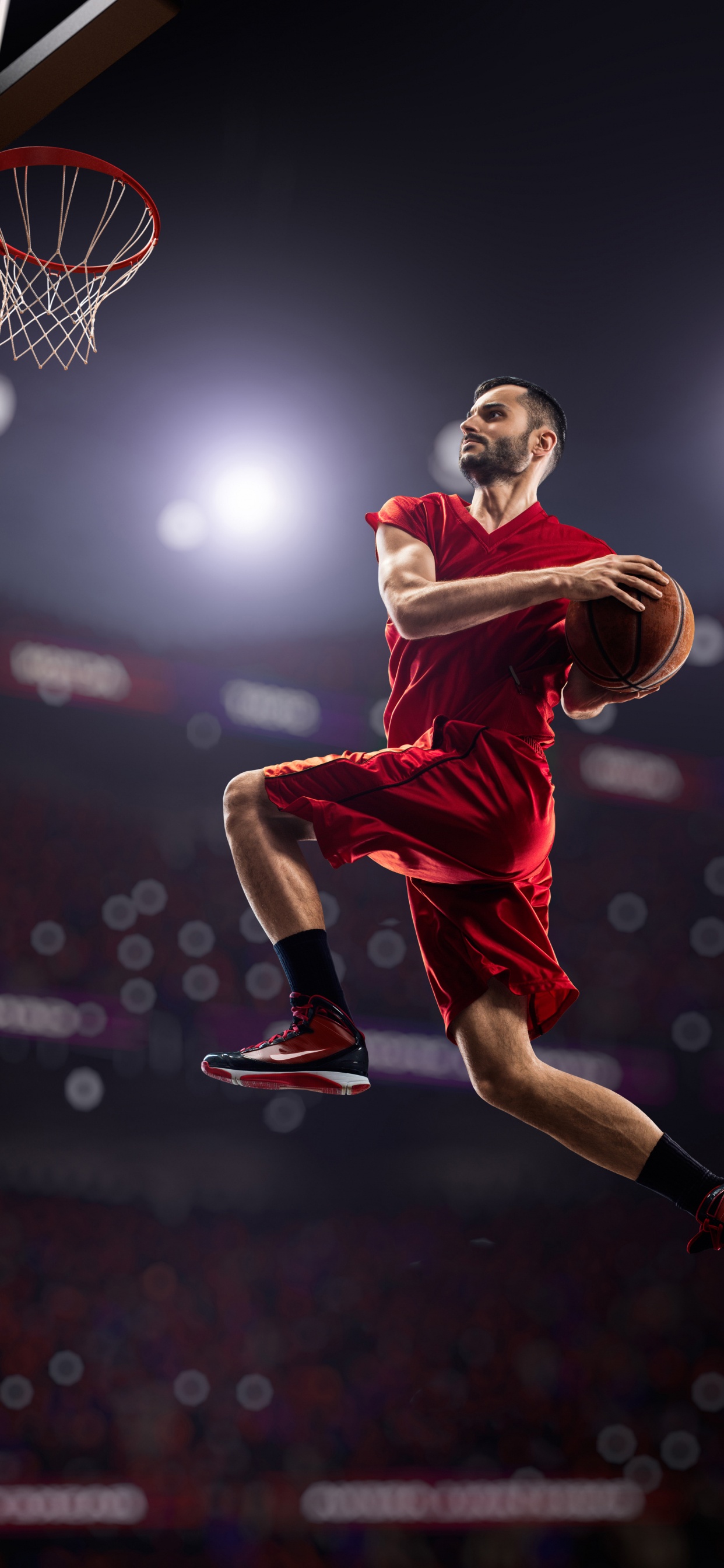 Hombre en Camiseta Roja y Pantalones Cortos Saltando en la Cancha de Baloncesto. Wallpaper in 1242x2688 Resolution