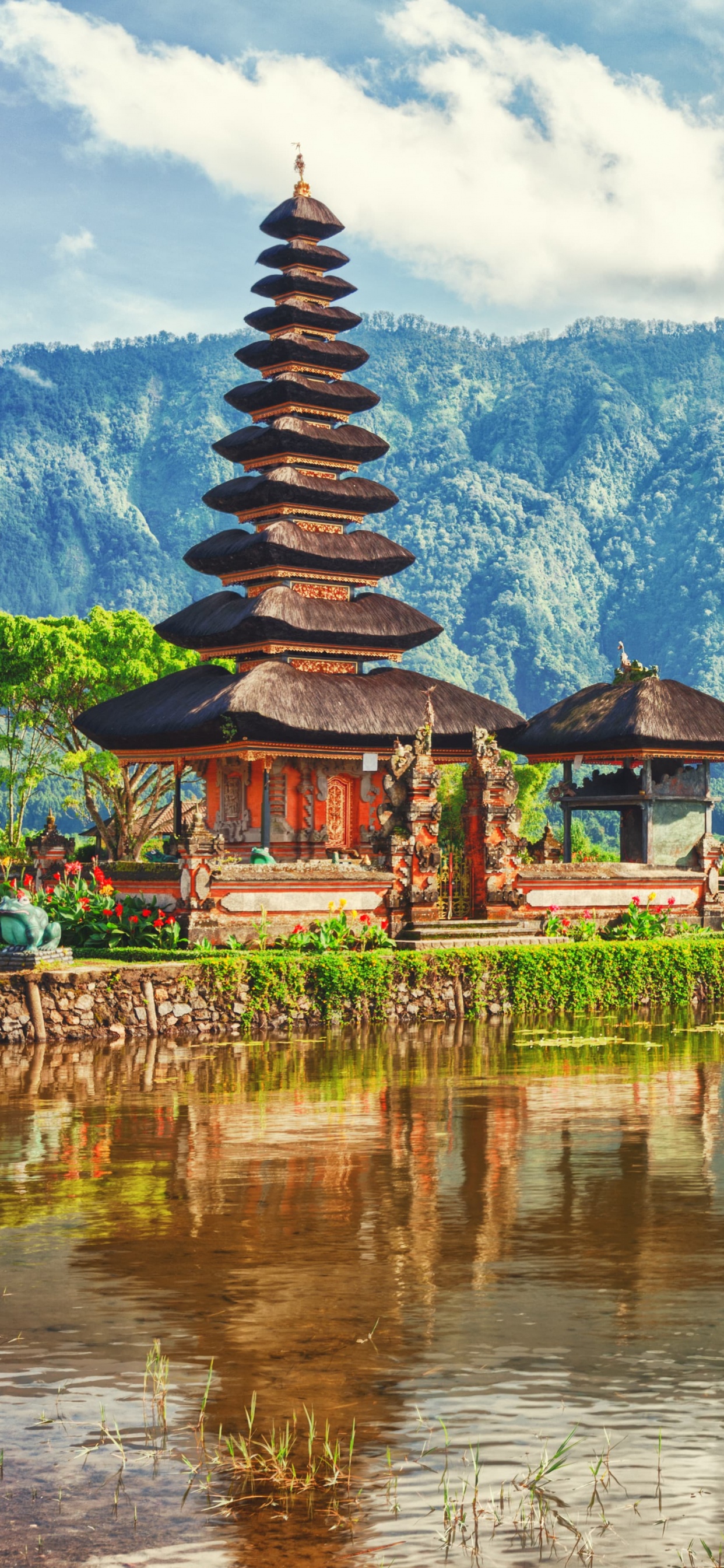 Templo Marrón y Verde Cerca Del Cuerpo de Agua y la Montaña Verde Durante el Día. Wallpaper in 1242x2688 Resolution