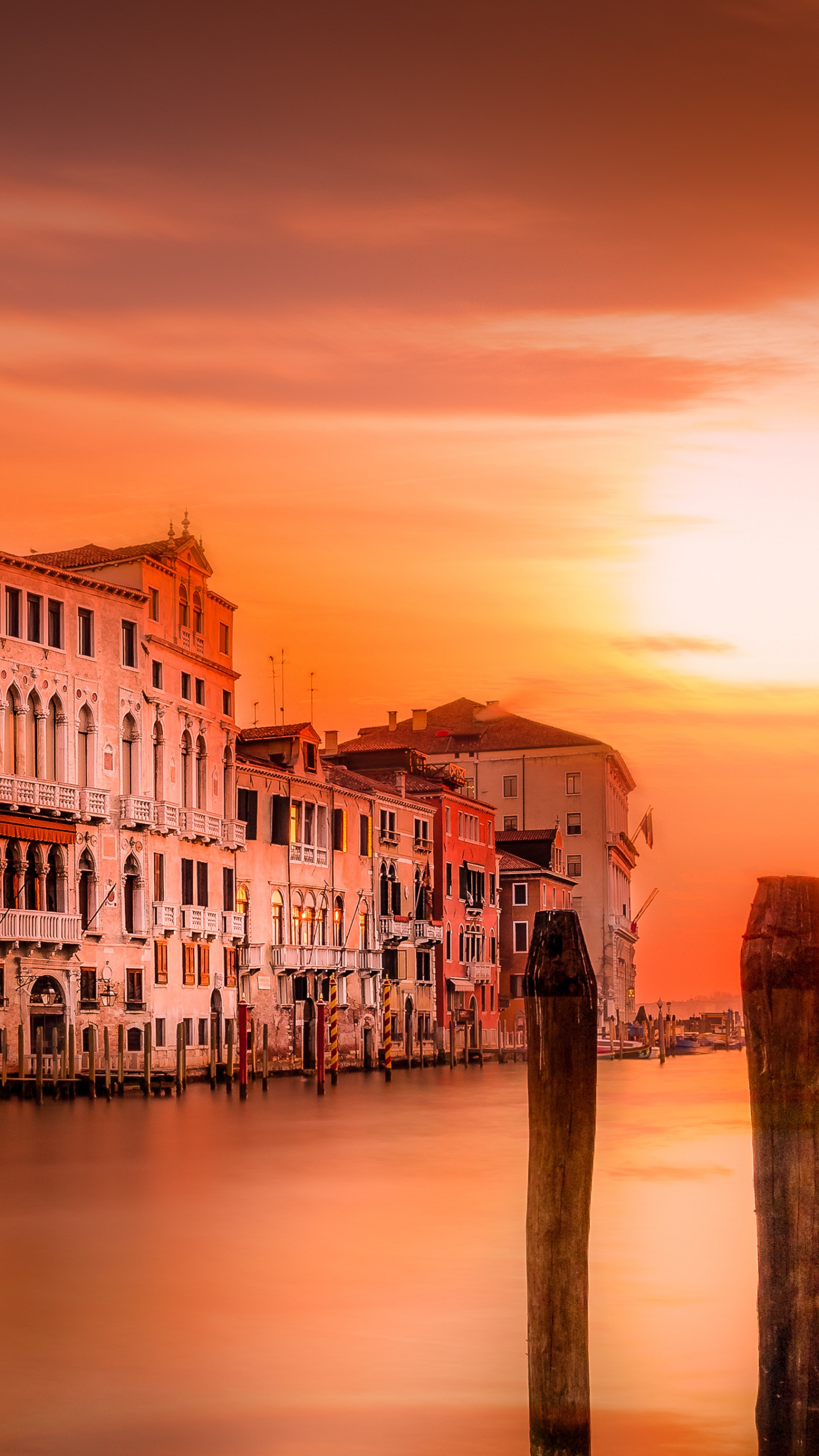 White and Brown Concrete Building Near Body of Water During Sunset. Wallpaper in 1440x2560 Resolution