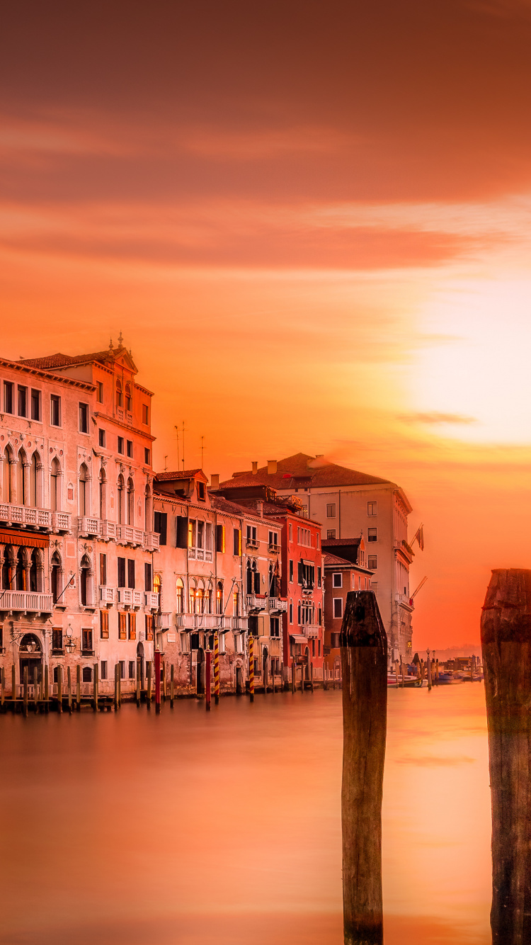 White and Brown Concrete Building Near Body of Water During Sunset. Wallpaper in 750x1334 Resolution