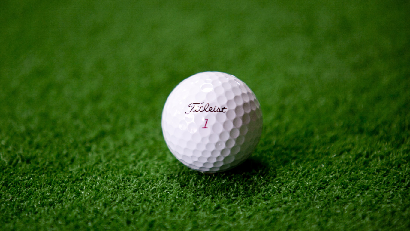 White Golf Ball on Green Grass. Wallpaper in 1366x768 Resolution