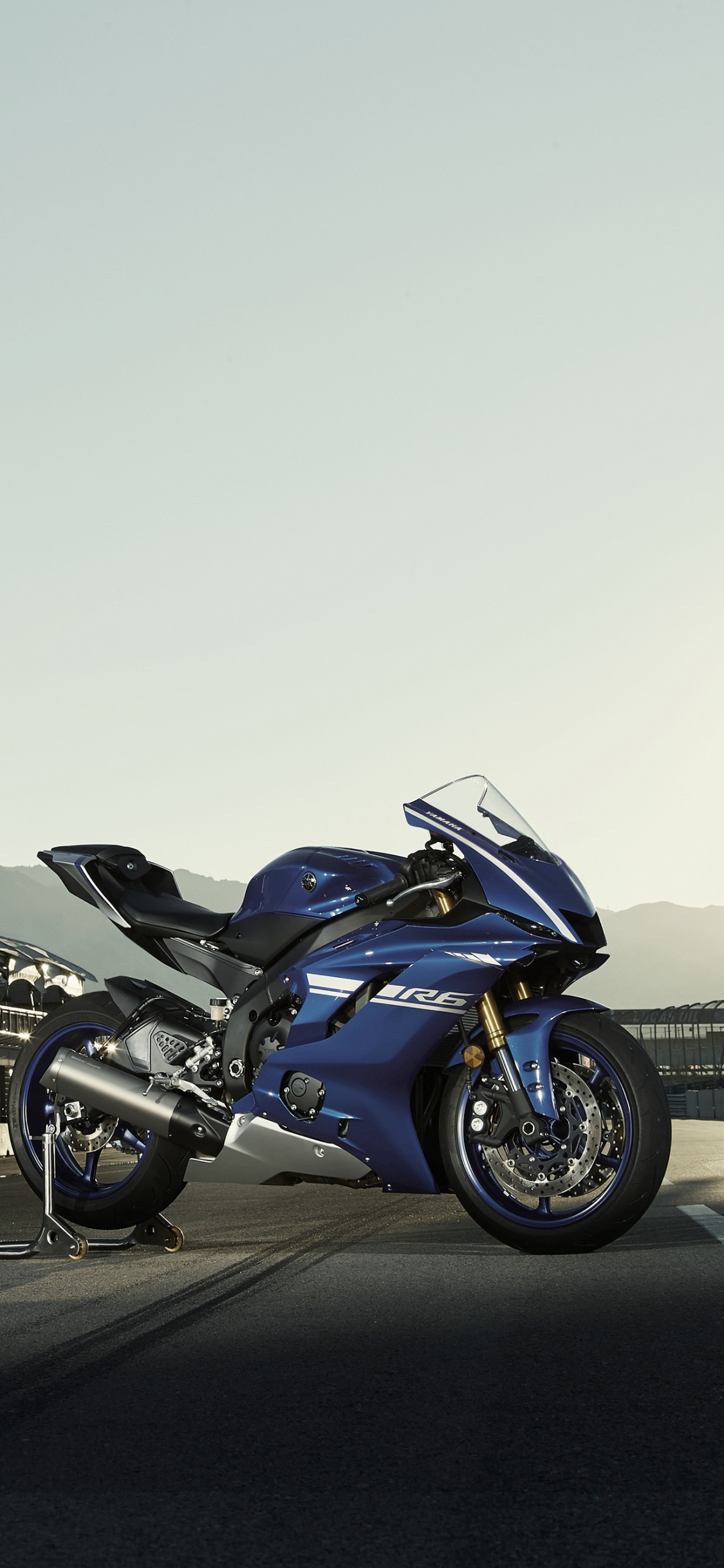 Blue and Black Sports Bike Parked on Gray Concrete Road During Daytime. Wallpaper in 1125x2436 Resolution