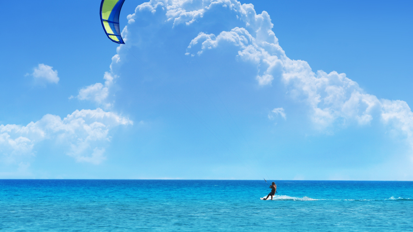 Hombre en Pantalones Cortos Azul Sosteniendo Azul y Negro Kite Surf en el Mar Durante el Día. Wallpaper in 1366x768 Resolution