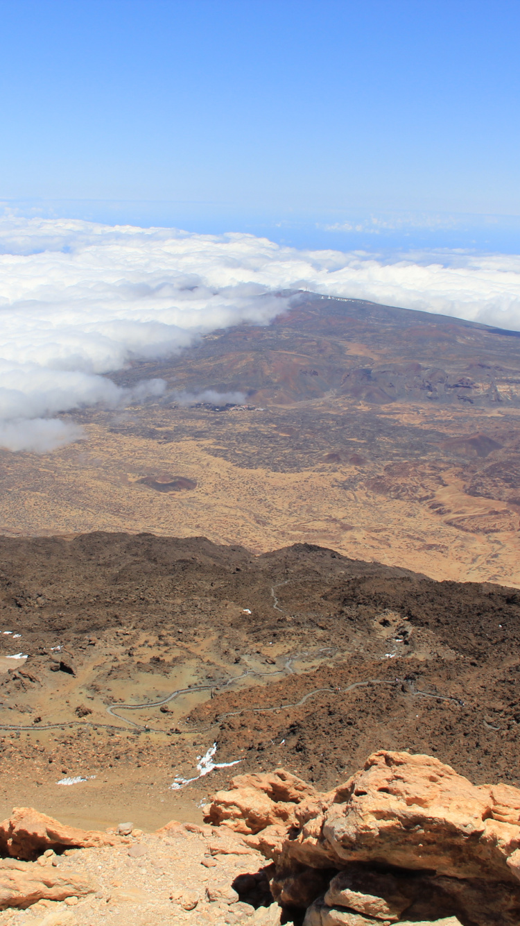 Montaña Rocosa Marrón Bajo un Cielo Azul Durante el Día. Wallpaper in 750x1334 Resolution
