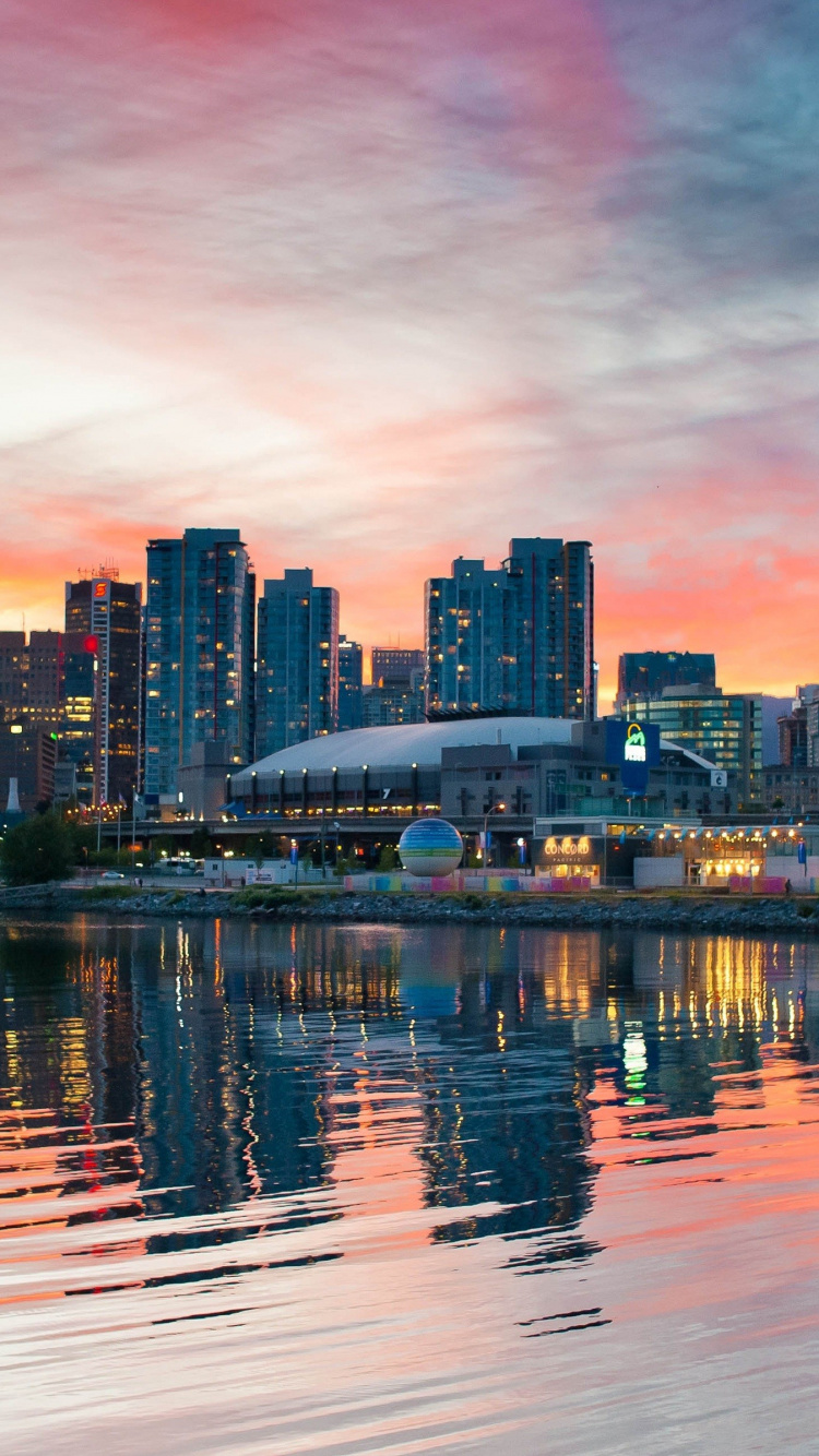 City Skyline Across Body of Water During Sunset. Wallpaper in 750x1334 Resolution