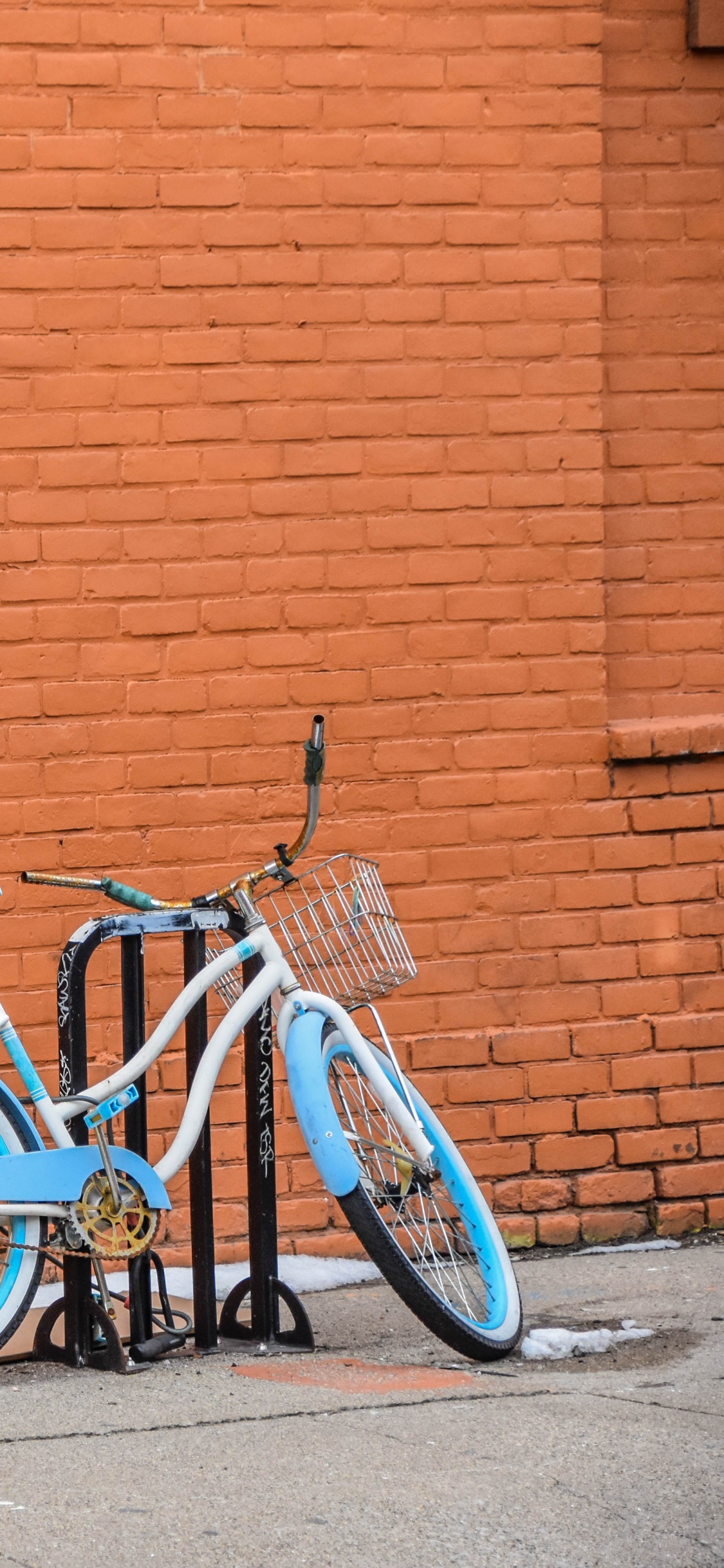 Bicicleta de Ciudad Azul Estacionada Junto a la Pared de Ladrillo Marrón. Wallpaper in 1125x2436 Resolution