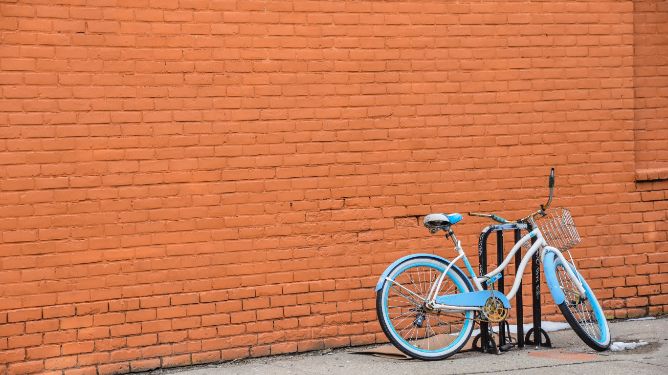 Blue City Bike Parked Beside Brown Brick Wall. Wallpaper in 1366x768 Resolution