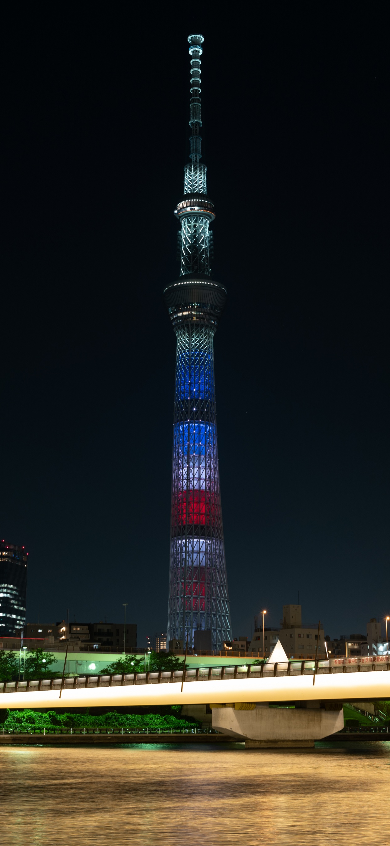 Torre Iluminada Durante la Noche. Wallpaper in 1242x2688 Resolution