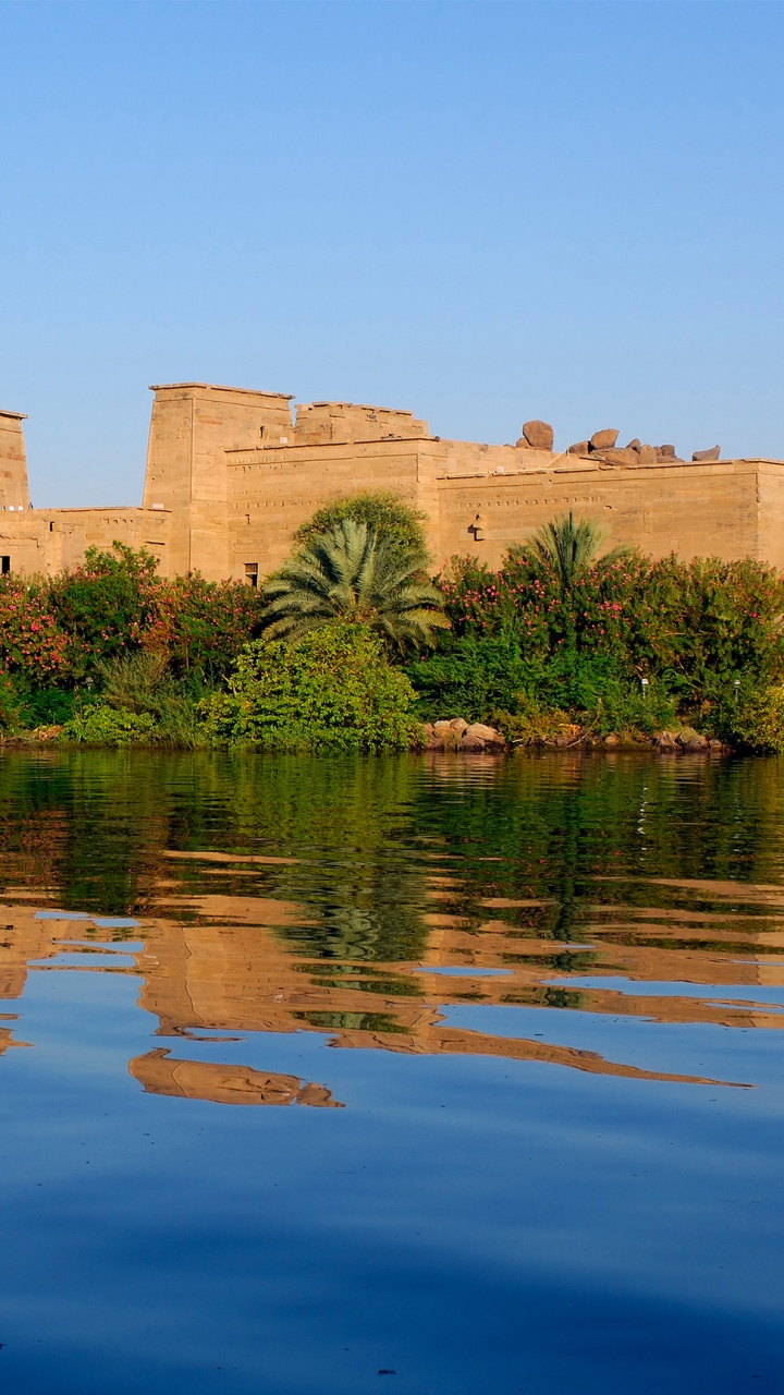Brown Concrete Building Near Body of Water During Daytime. Wallpaper in 720x1280 Resolution