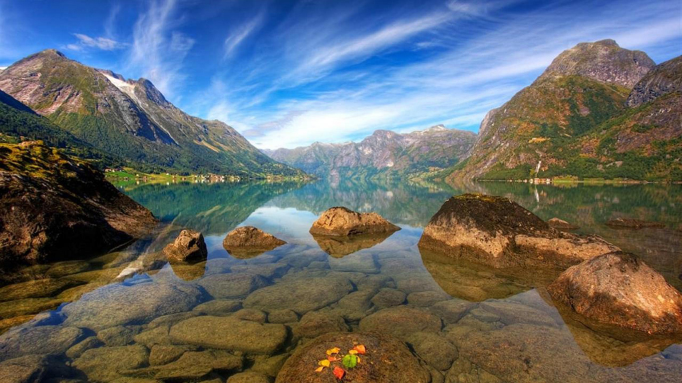 Green and Brown Mountain Beside Lake Under Blue Sky During Daytime. Wallpaper in 1366x768 Resolution