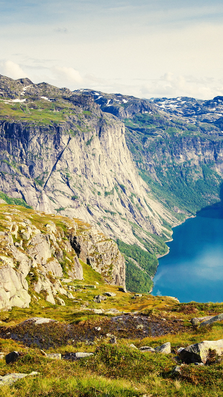 Lago Azul Entre Montañas Rocosas Grises Bajo el Cielo Nublado Blanco Durante el Día. Wallpaper in 750x1334 Resolution