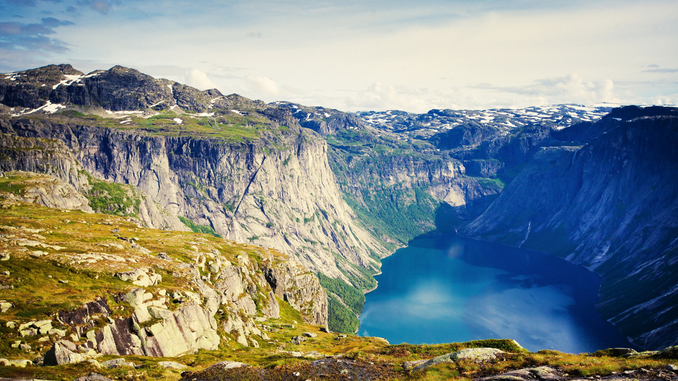 Blue Lake Between Gray Rocky Mountains Under White Cloudy Sky During Daytime. Wallpaper in 1366x768 Resolution