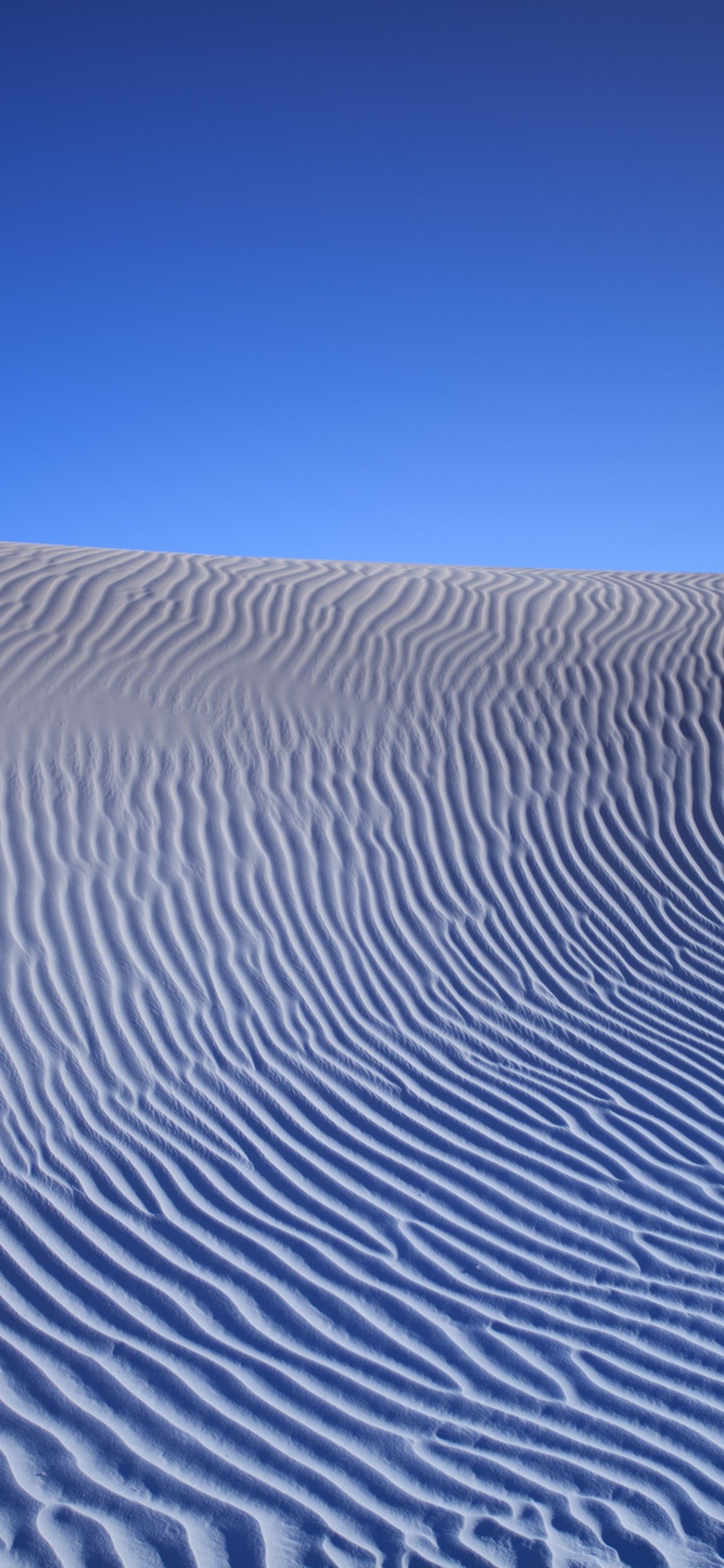 Desierto Bajo un Cielo Azul Durante el Día. Wallpaper in 1125x2436 Resolution