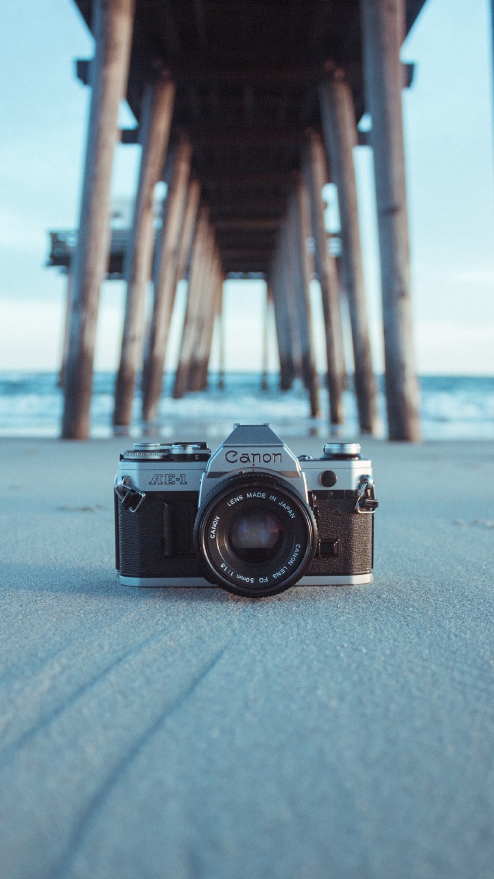 Cámara Negra y Plateada Sobre Arena Gris Durante el Día. Wallpaper in 720x1280 Resolution