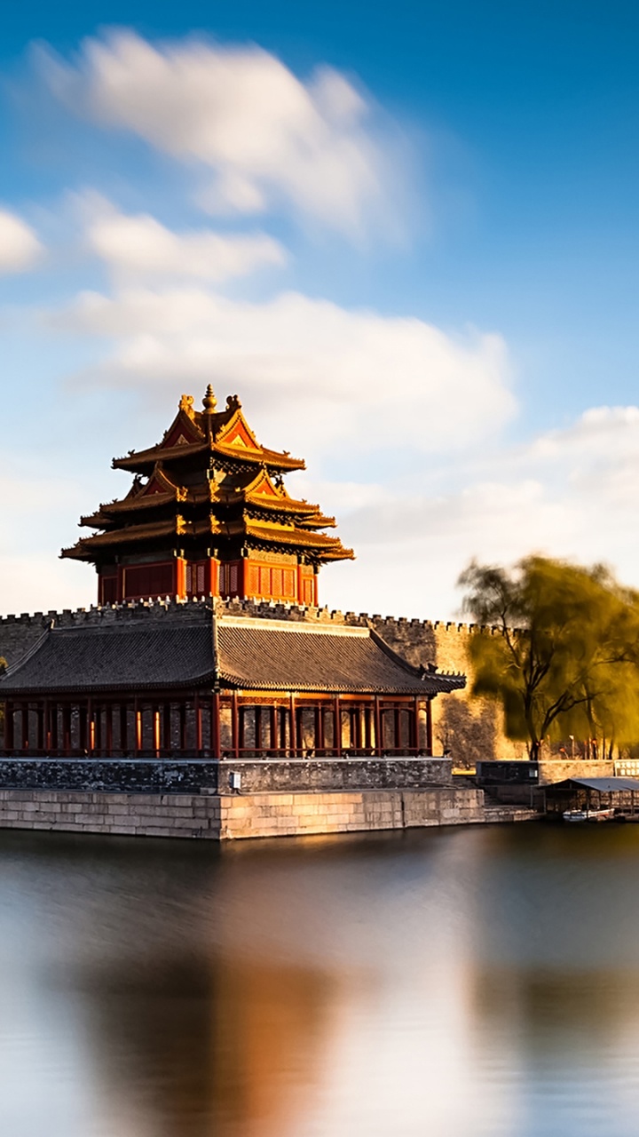 Templo Marrón y Negro Cerca de Árboles Verdes y Río Bajo un Cielo Azul Durante el Día. Wallpaper in 720x1280 Resolution