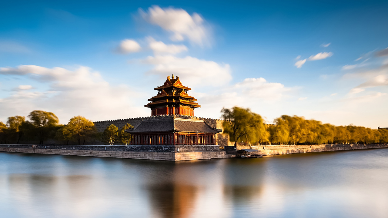 Brown and Black Temple Near Green Trees and River Under Blue Sky During Daytime. Wallpaper in 1280x720 Resolution