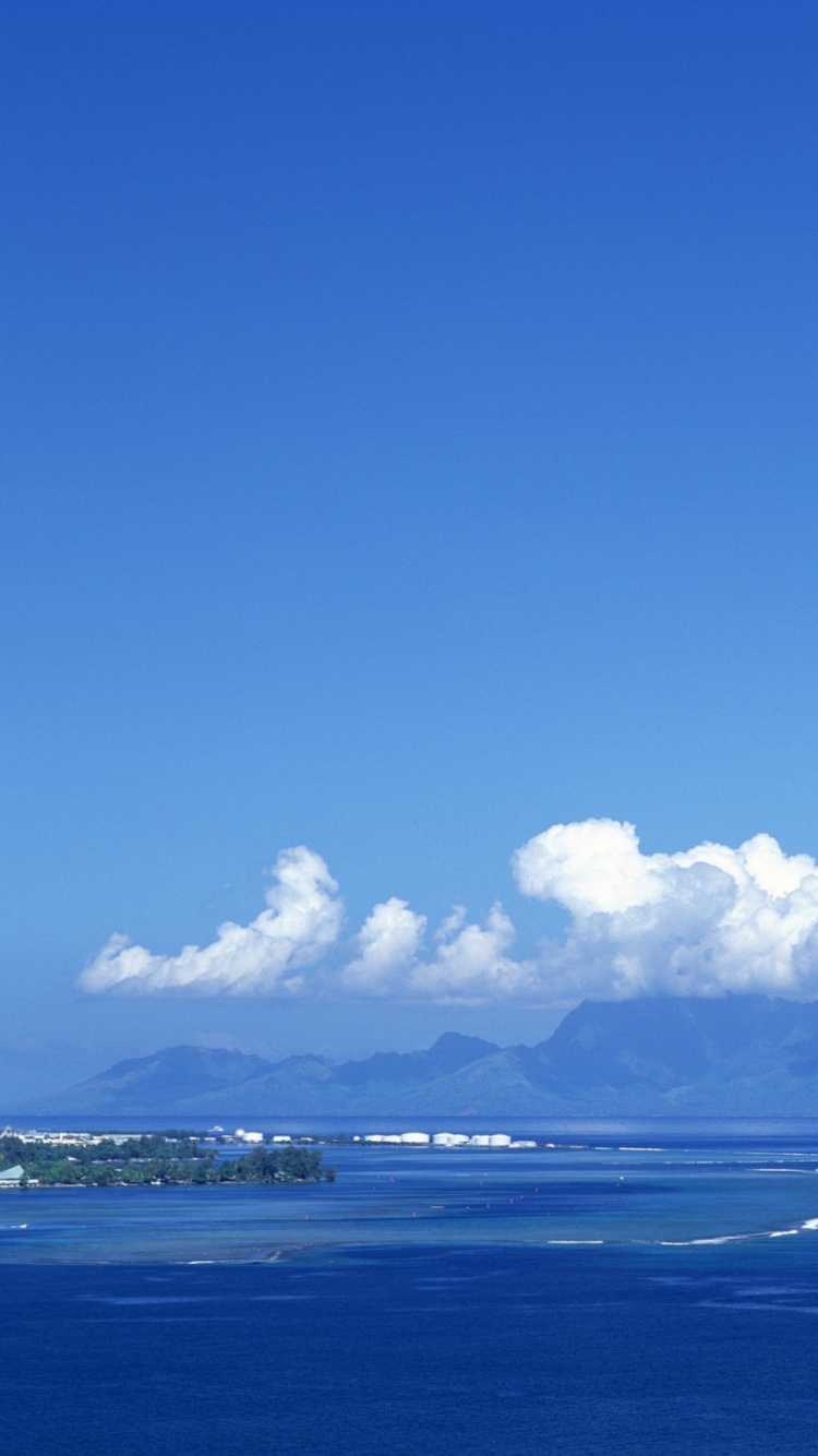 Mar Azul Bajo un Cielo Azul Durante el Día. Wallpaper in 750x1334 Resolution