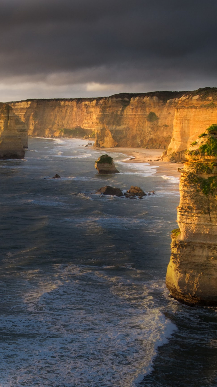 Montaña Rocosa Gris Junto al Cuerpo de Agua Durante el Día. Wallpaper in 750x1334 Resolution