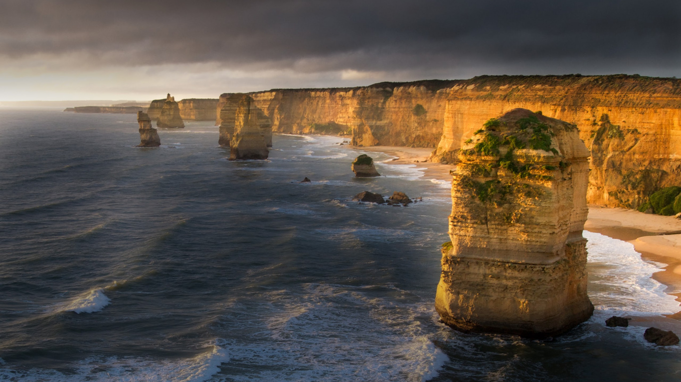 Grauer Felsiger Berg Neben Gewässer Tagsüber. Wallpaper in 1366x768 Resolution