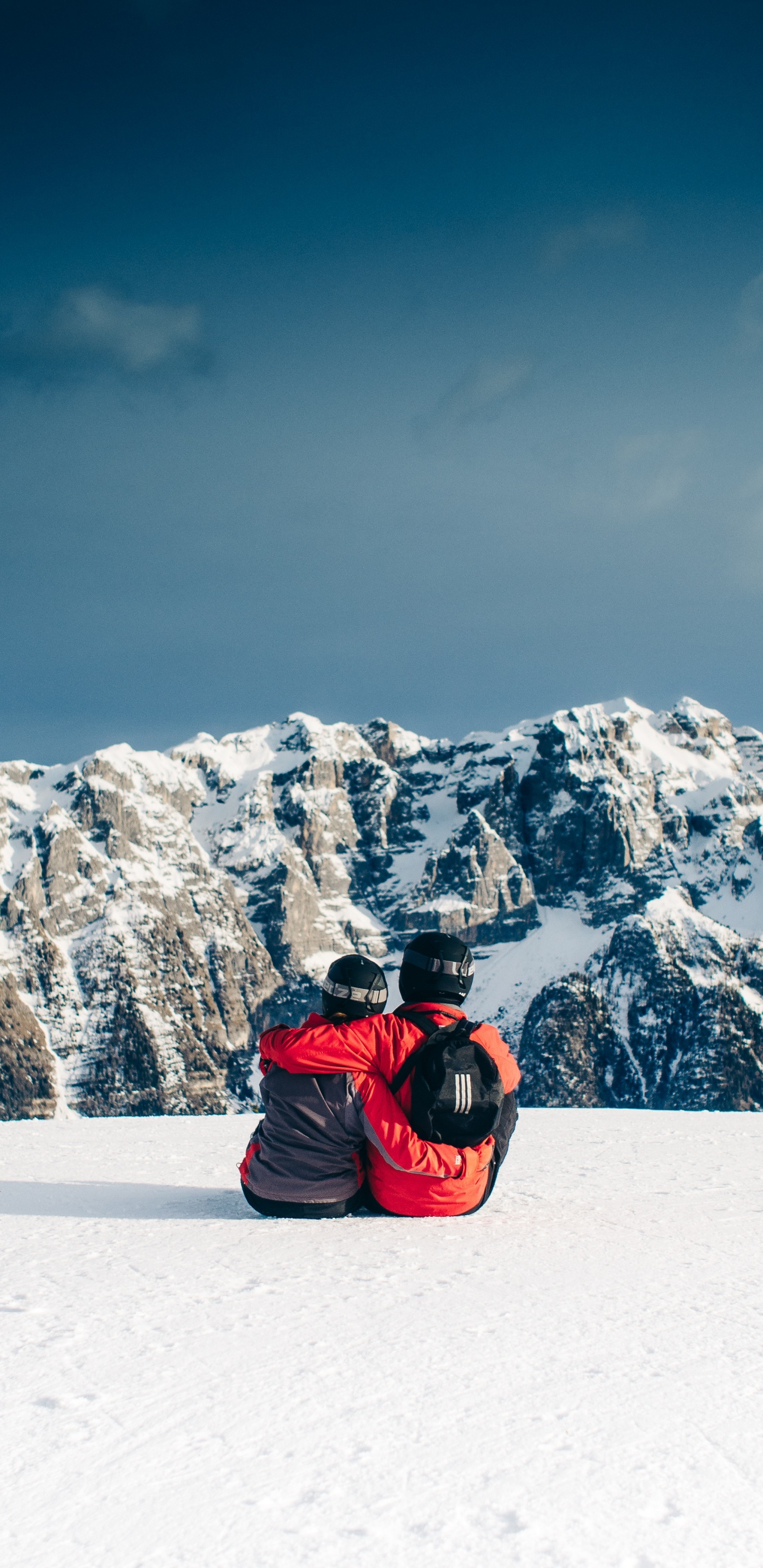 Persona Con Chaqueta Roja Sentada Sobre un Suelo Cubierto de Nieve. Wallpaper in 1440x2960 Resolution