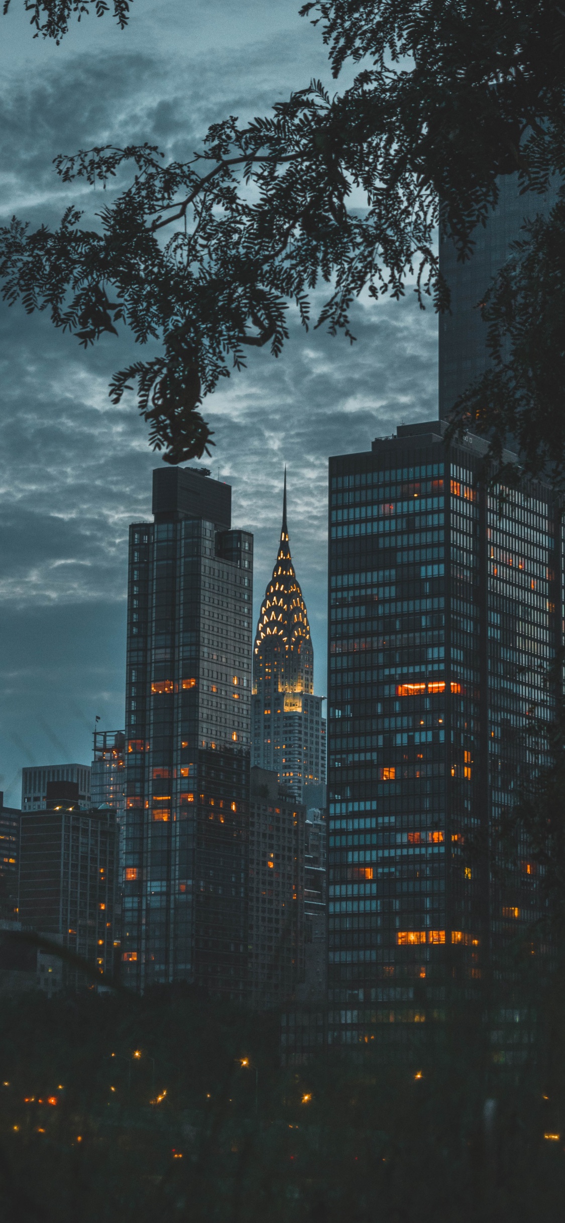 Immeubles de Grande Hauteur Sous Des Nuages Gris. Wallpaper in 1125x2436 Resolution