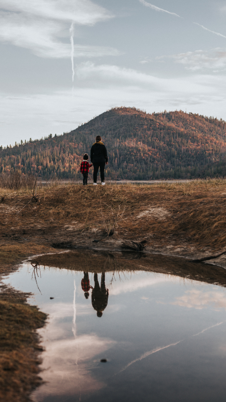 2 Personne Debout Sur un Terrain D'herbe Brune Près du Lac Pendant la Journée. Wallpaper in 750x1334 Resolution