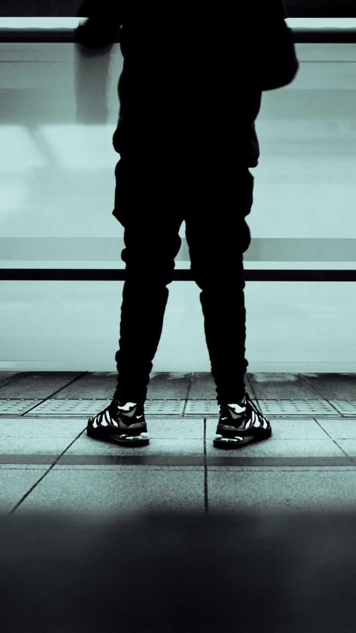 Person in Black Pants and Black Shoes Standing on Gray Floor. Wallpaper in 720x1280 Resolution