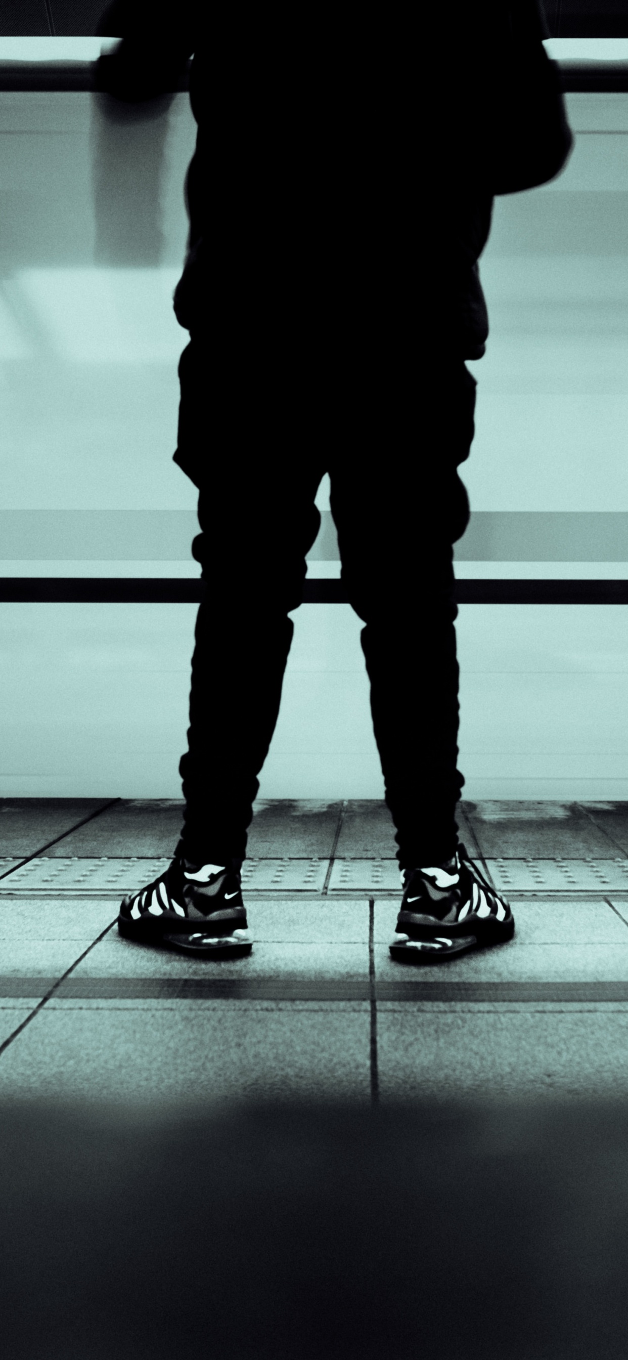 Persona en Pantalones Negros y Zapatos Negros de Pie Sobre un Piso Gris. Wallpaper in 1242x2688 Resolution