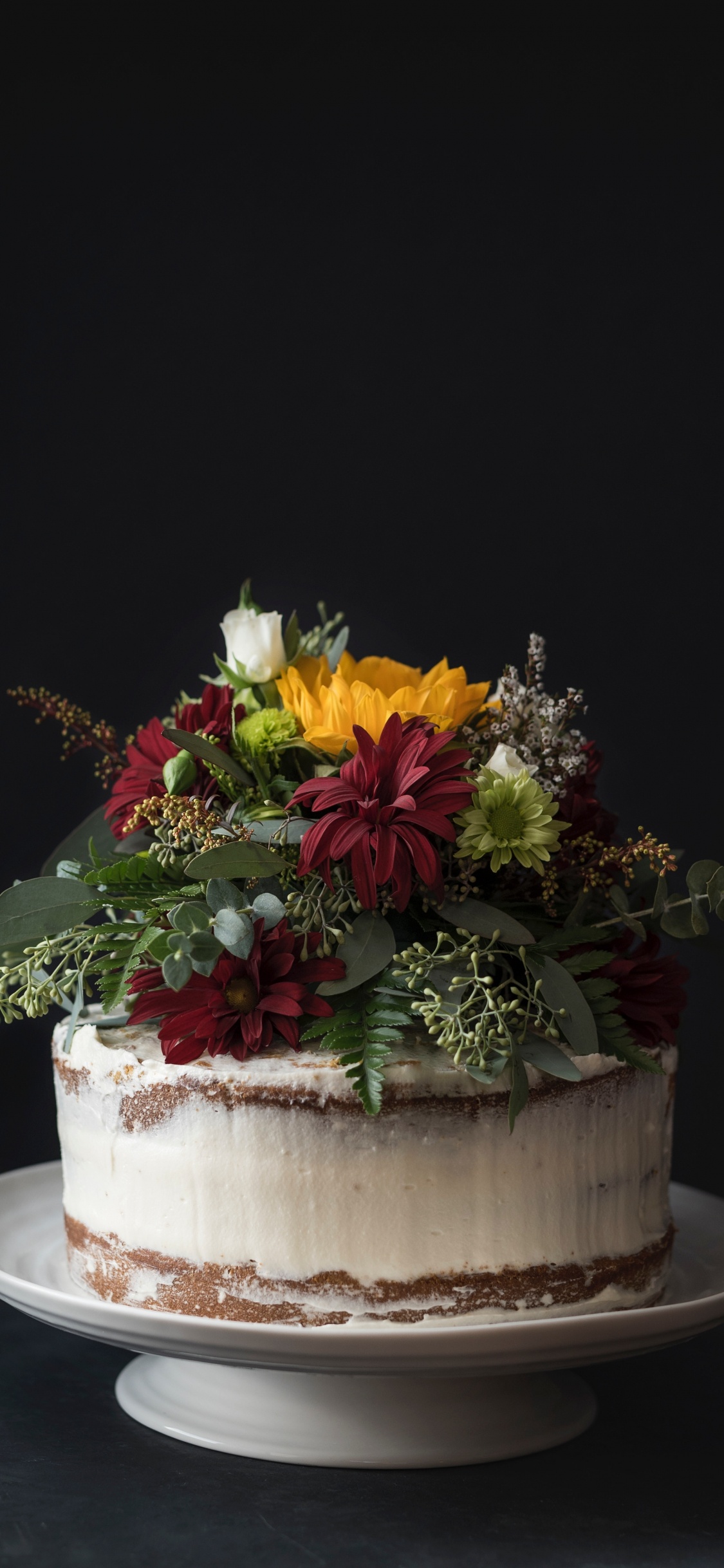 Yellow and Red Flowers on White Ceramic Vase. Wallpaper in 1125x2436 Resolution