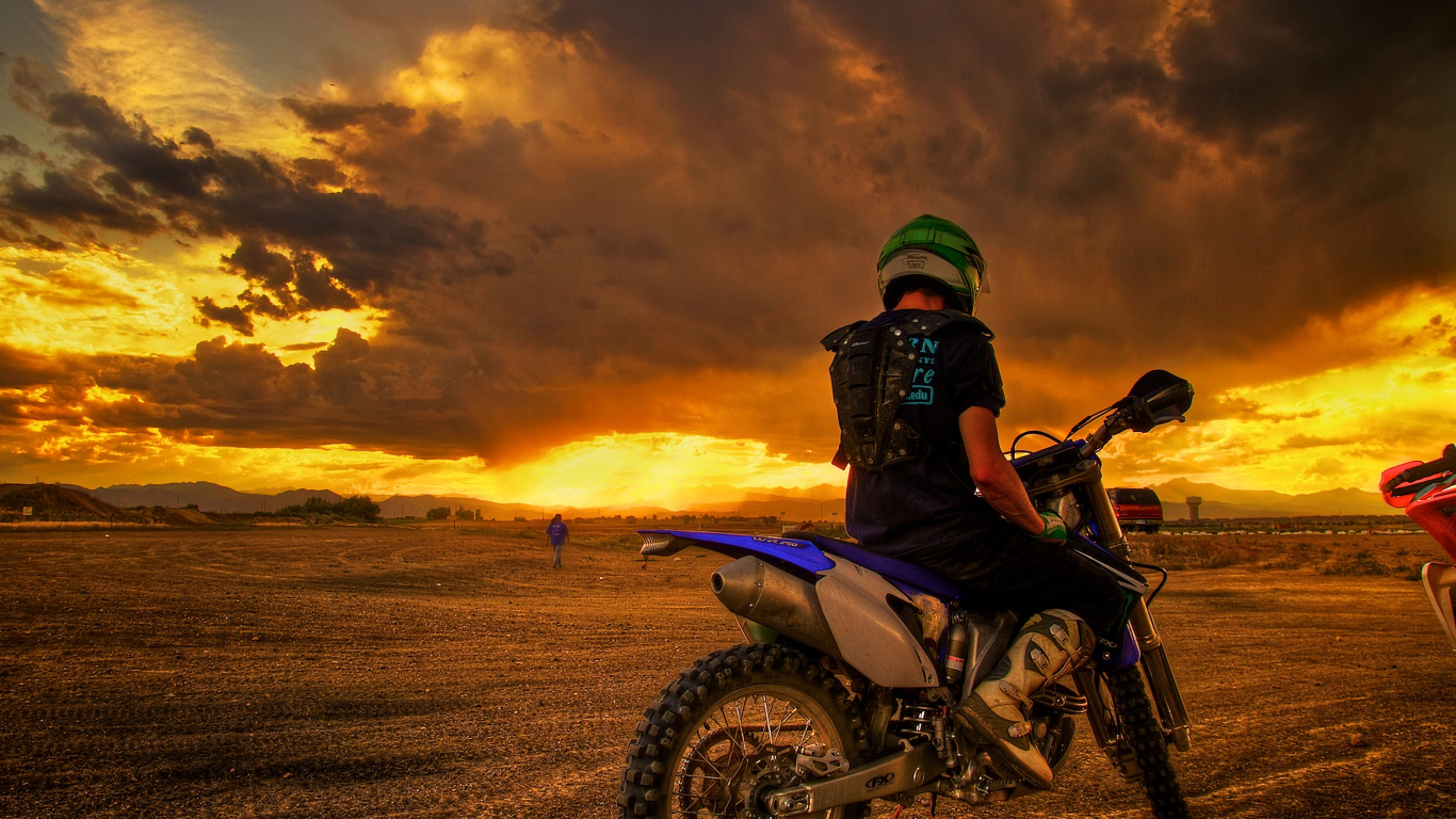 Man Riding Motorcycle on Brown Field During Sunset. Wallpaper in 1366x768 Resolution