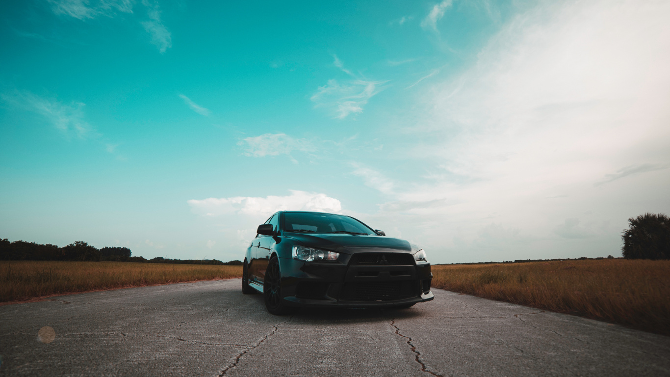Schwarzes Auto Auf Grauer Asphaltstraße Unter Blauem Himmel Tagsüber. Wallpaper in 1366x768 Resolution