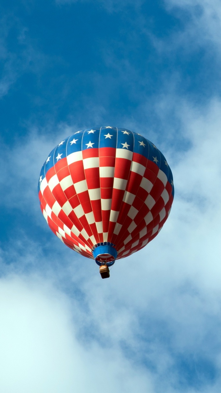 Globo de Aire Caliente Rojo Azul y Amarillo en el Aire Bajo Nubes Blancas y Cielo Azul. Wallpaper in 720x1280 Resolution
