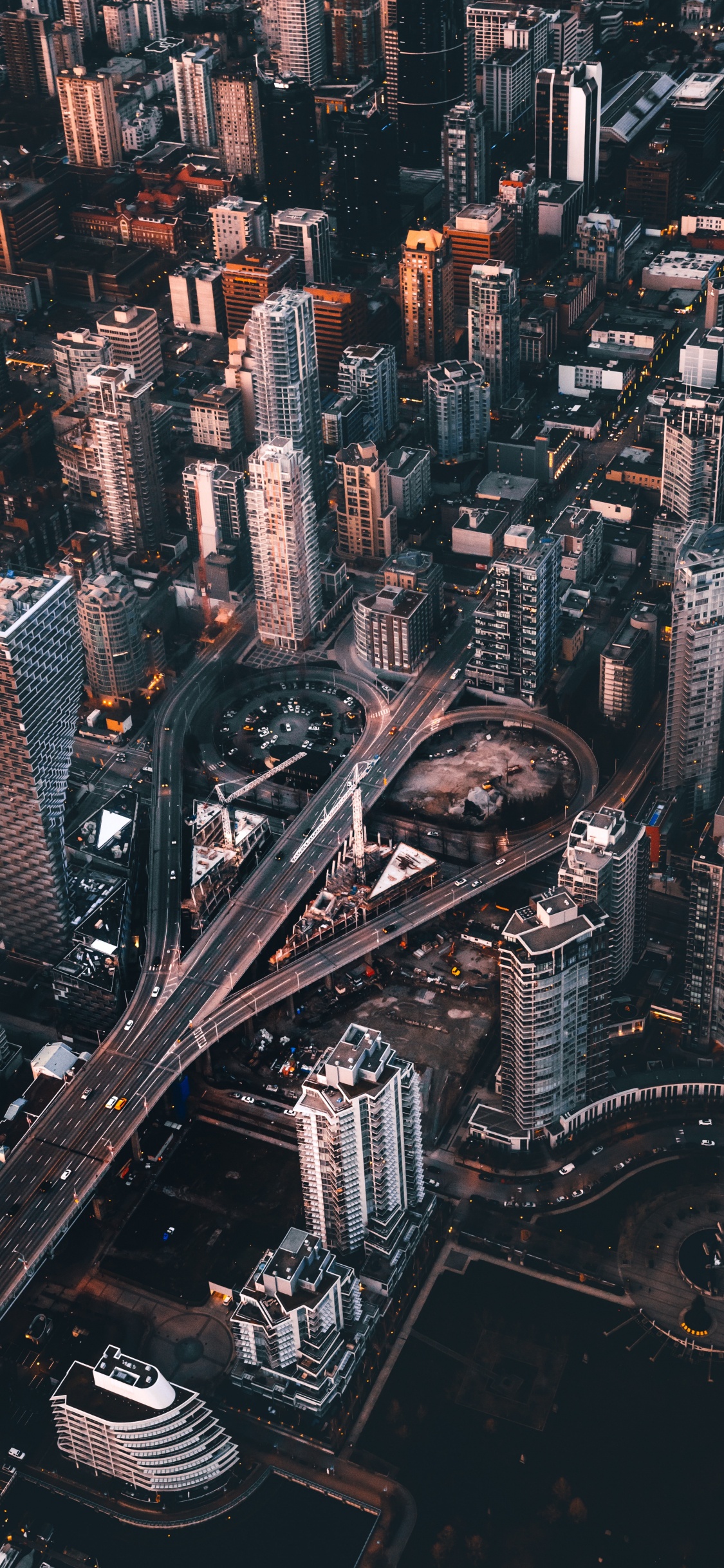 Vista Aérea de Los Edificios de la Ciudad Durante la Noche.. Wallpaper in 1125x2436 Resolution