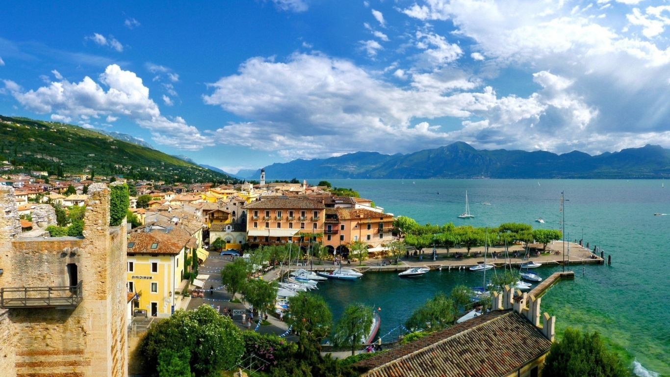Brown Concrete Building Near Body of Water Under Blue Sky During Daytime. Wallpaper in 1366x768 Resolution