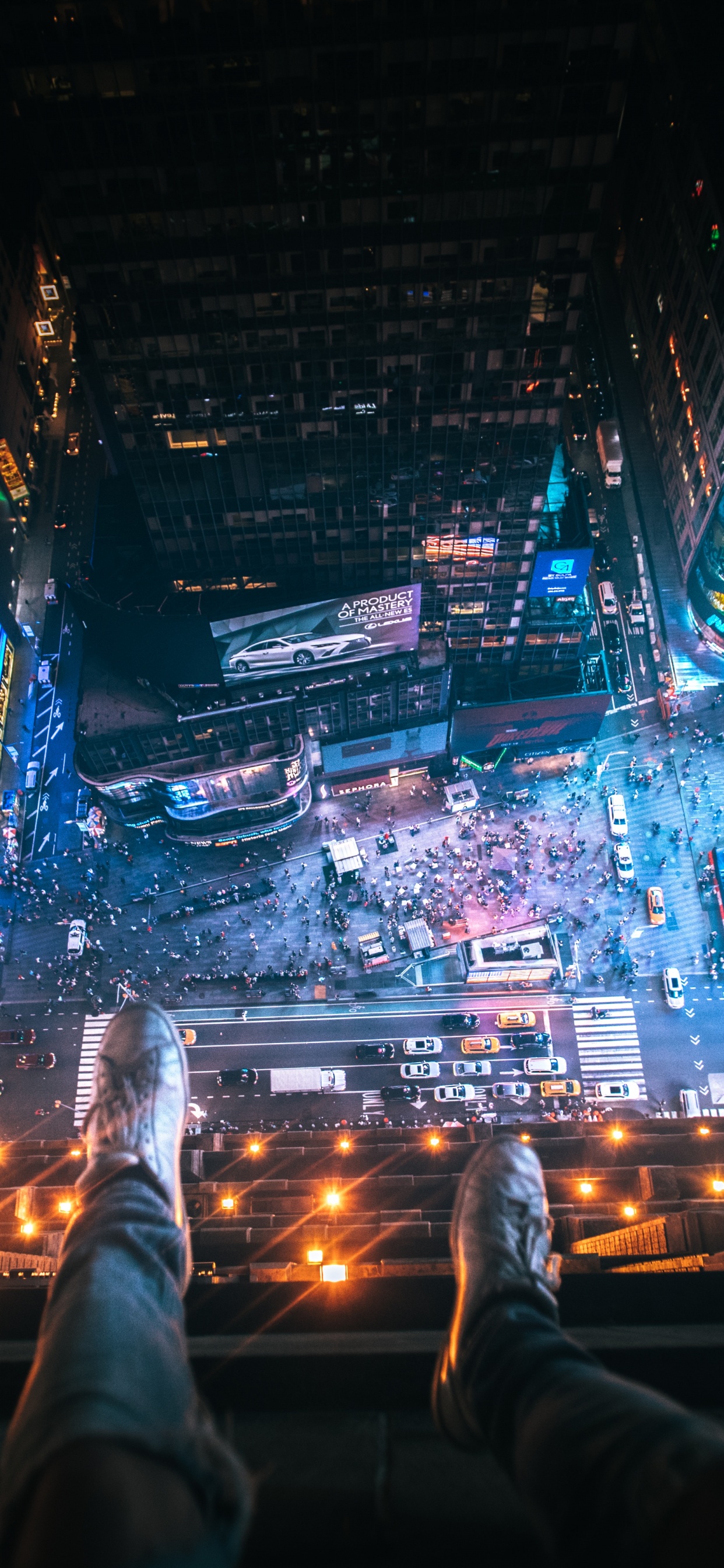 Person in Black Pants and Black Shoes on Top of The Building During Night Time. Wallpaper in 1242x2688 Resolution