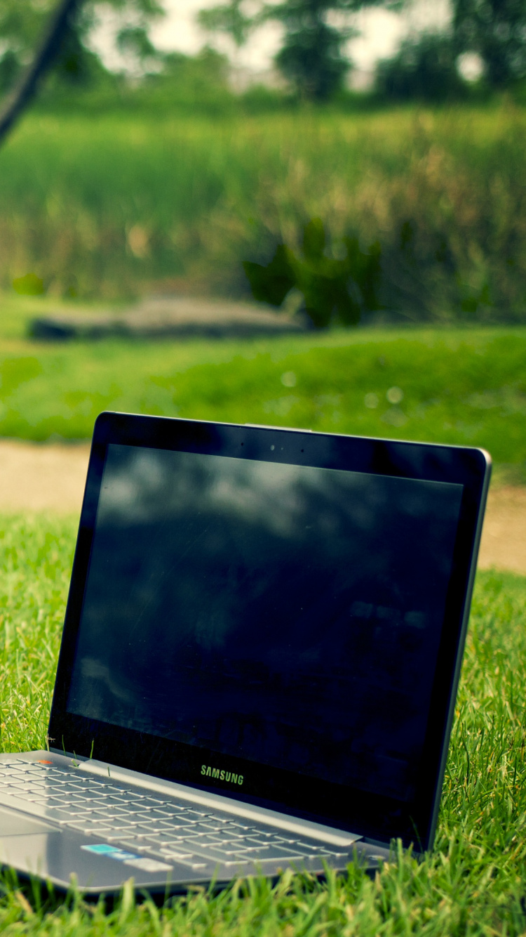 Black and Gray Laptop Computer on Green Grass During Daytime. Wallpaper in 750x1334 Resolution