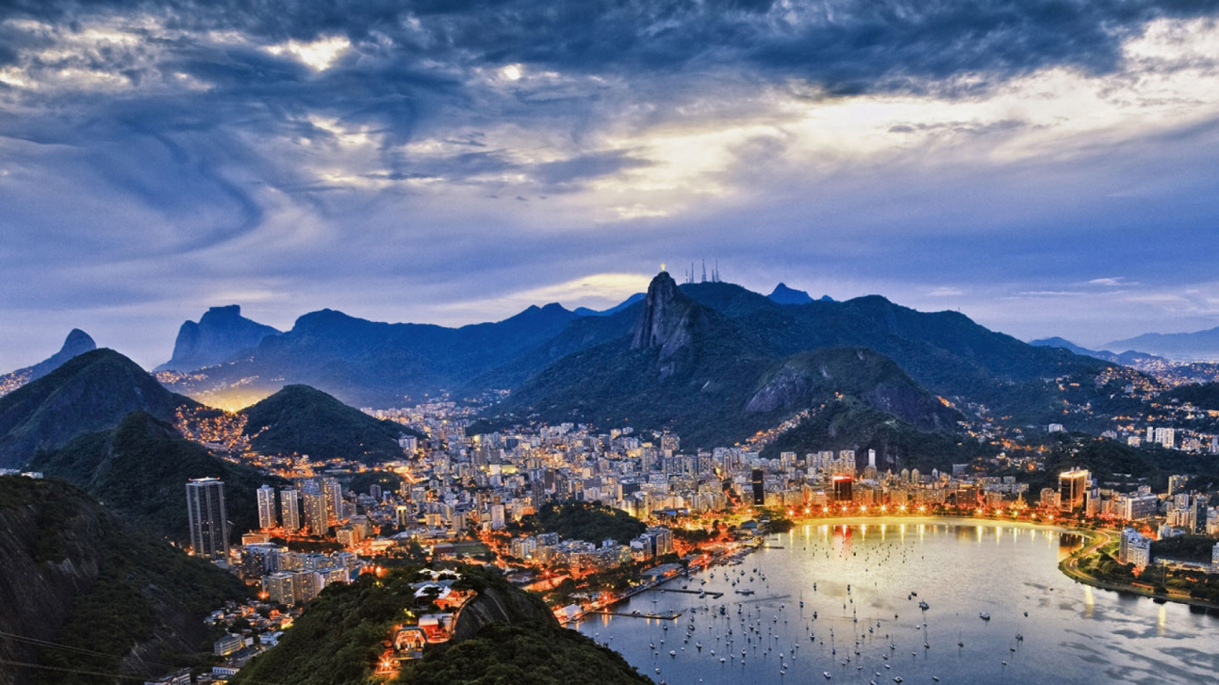 Edificios de la Ciudad Cerca Del Cuerpo de Agua Bajo el Cielo Nublado Durante el Día. Wallpaper in 1366x768 Resolution