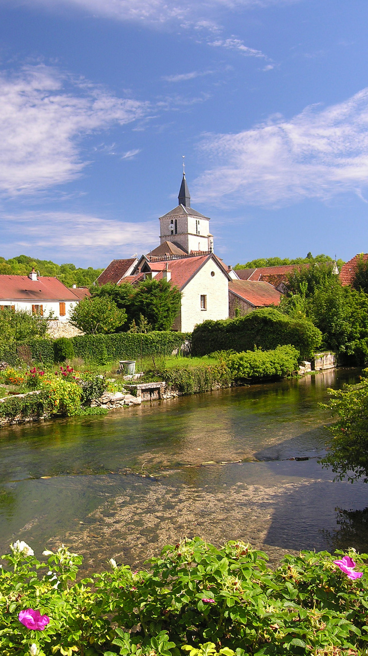 Bâtiment en Béton Blanc et Marron Près de la Rivière Sous un Ciel Bleu Pendant la Journée. Wallpaper in 750x1334 Resolution