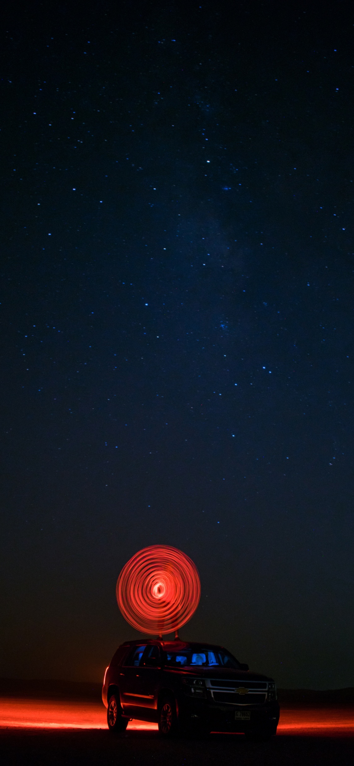 Tente Dôme Éclairée en Noir et Rouge Sous la Nuit Étoilée. Wallpaper in 1125x2436 Resolution