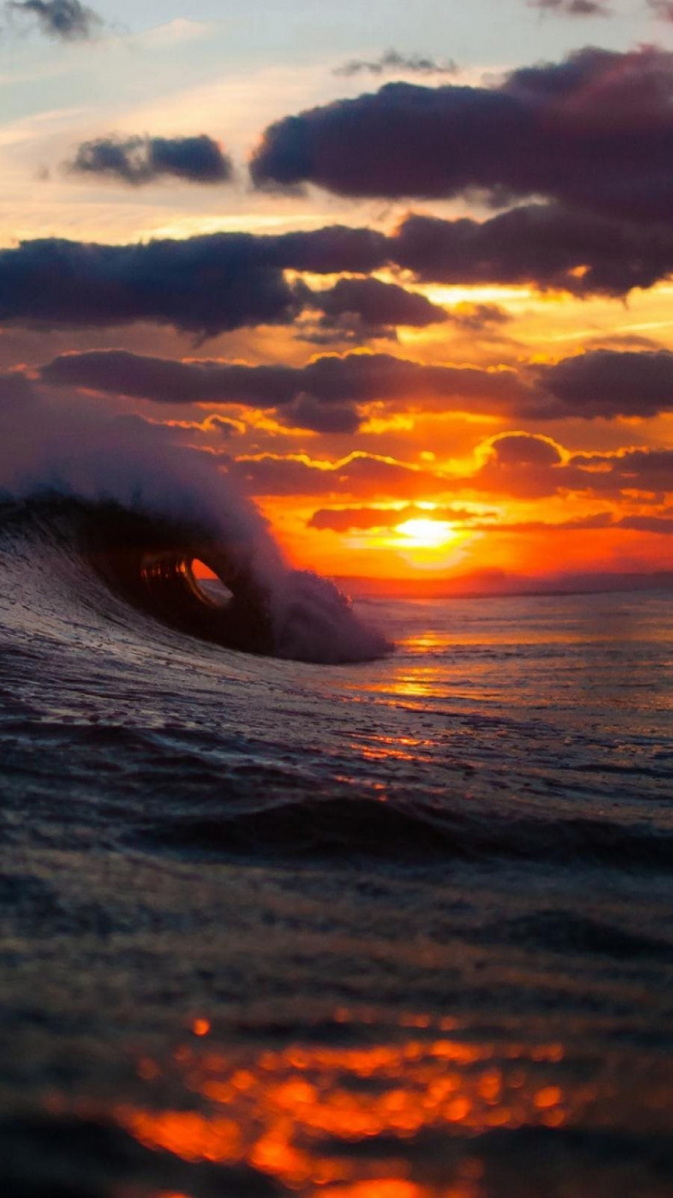 Olas Del Mar Rompiendo en la Orilla Durante la Puesta de Sol. Wallpaper in 750x1334 Resolution