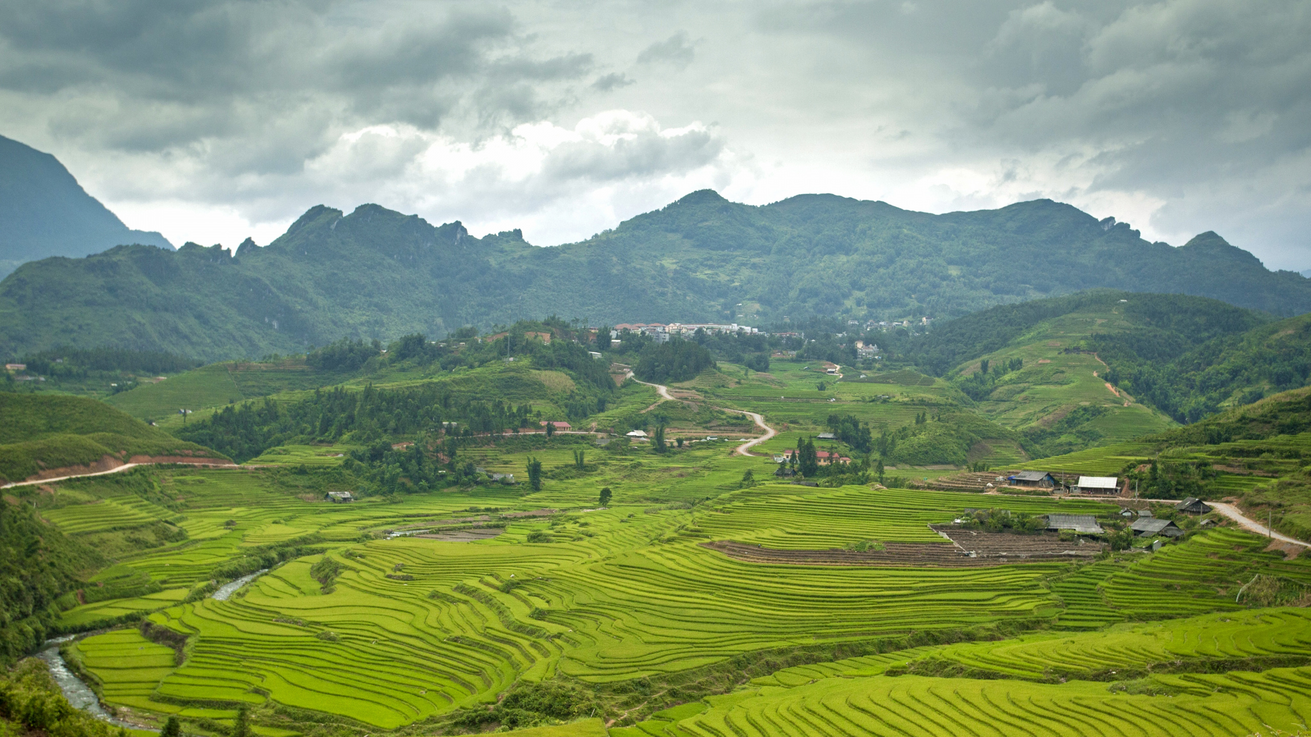 Green Grass Field Near Mountain Under White Clouds During Daytime. Wallpaper in 2560x1440 Resolution