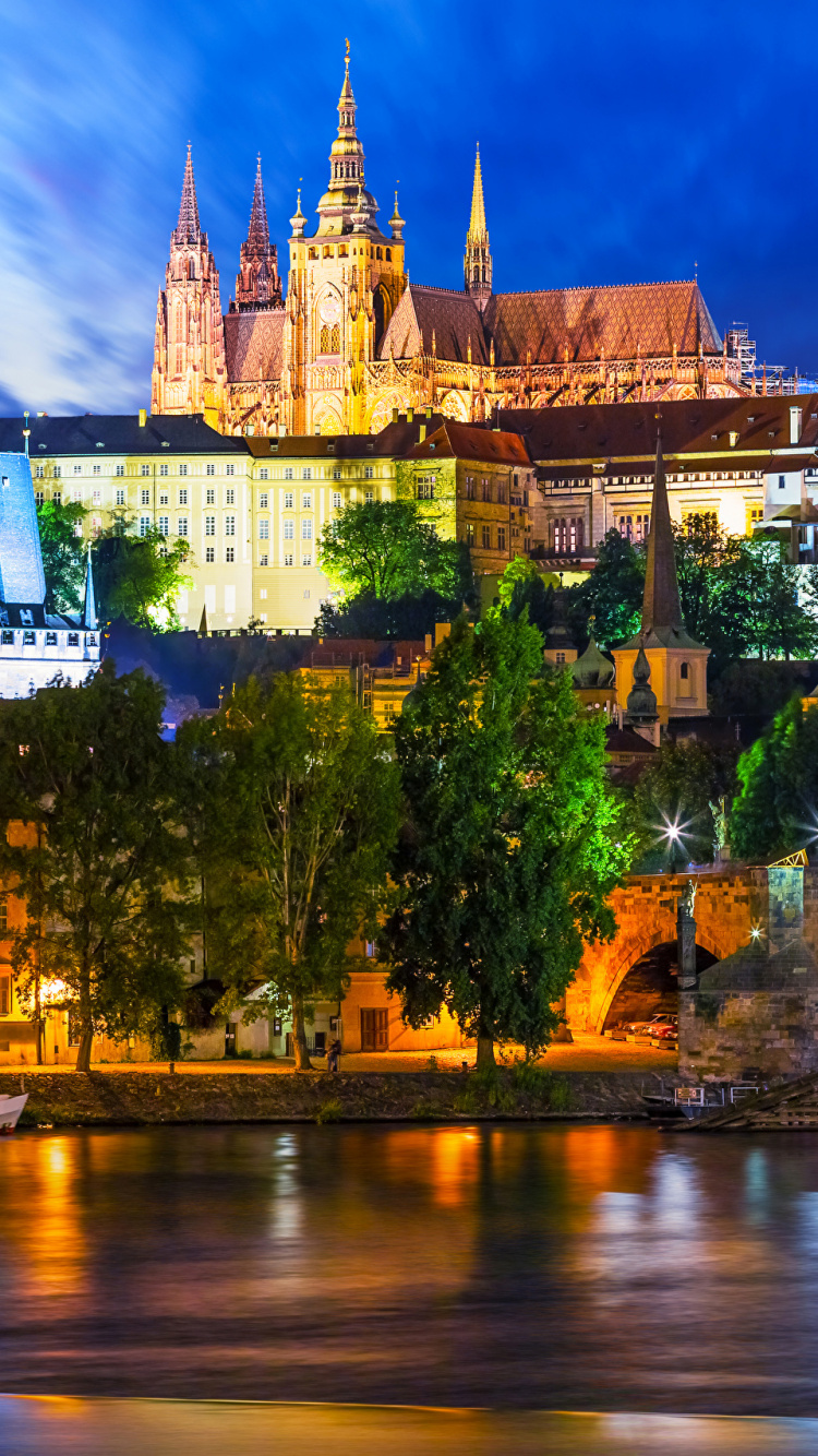 Braunes Und Weißes Betongebäude in Der Nähe Eines Gewässers Während Der Nacht. Wallpaper in 750x1334 Resolution