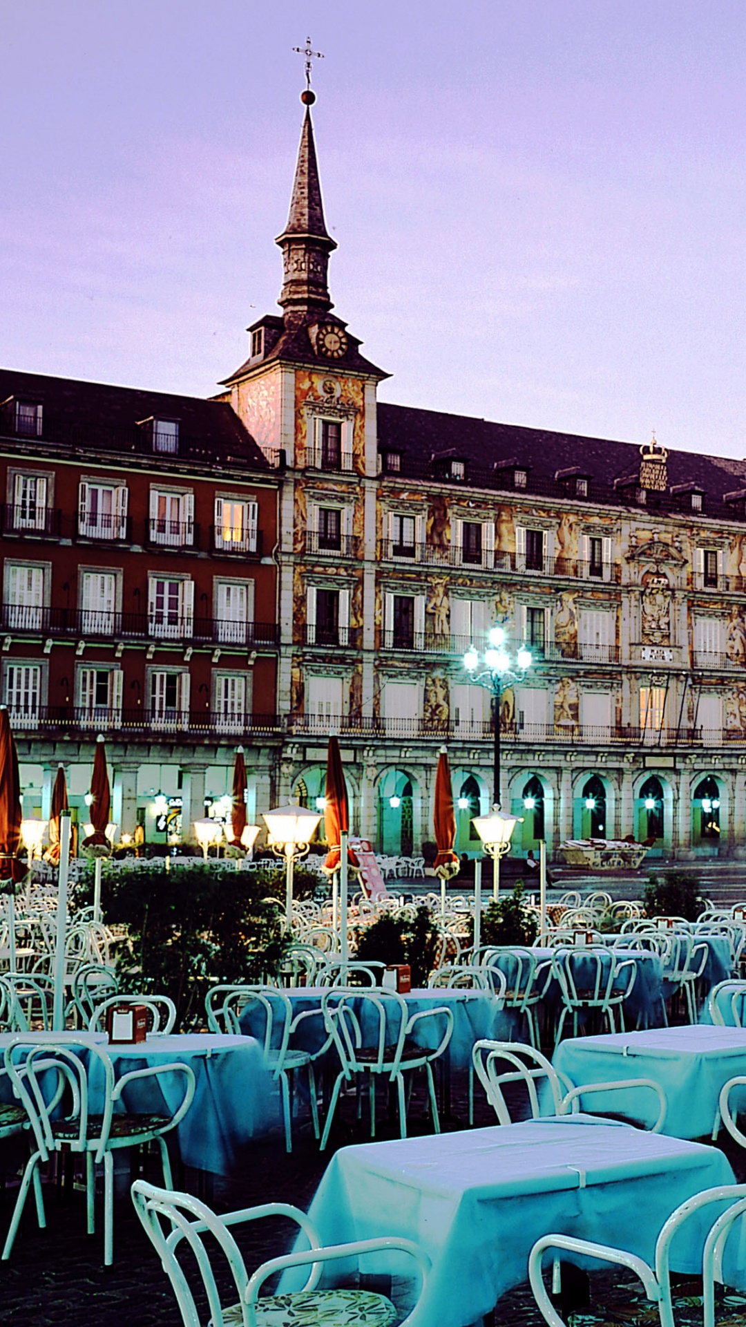Sillas y Mesas Blancas y Azules Cerca Del Edificio de Hormigón Marrón Durante la Noche. Wallpaper in 1080x1920 Resolution