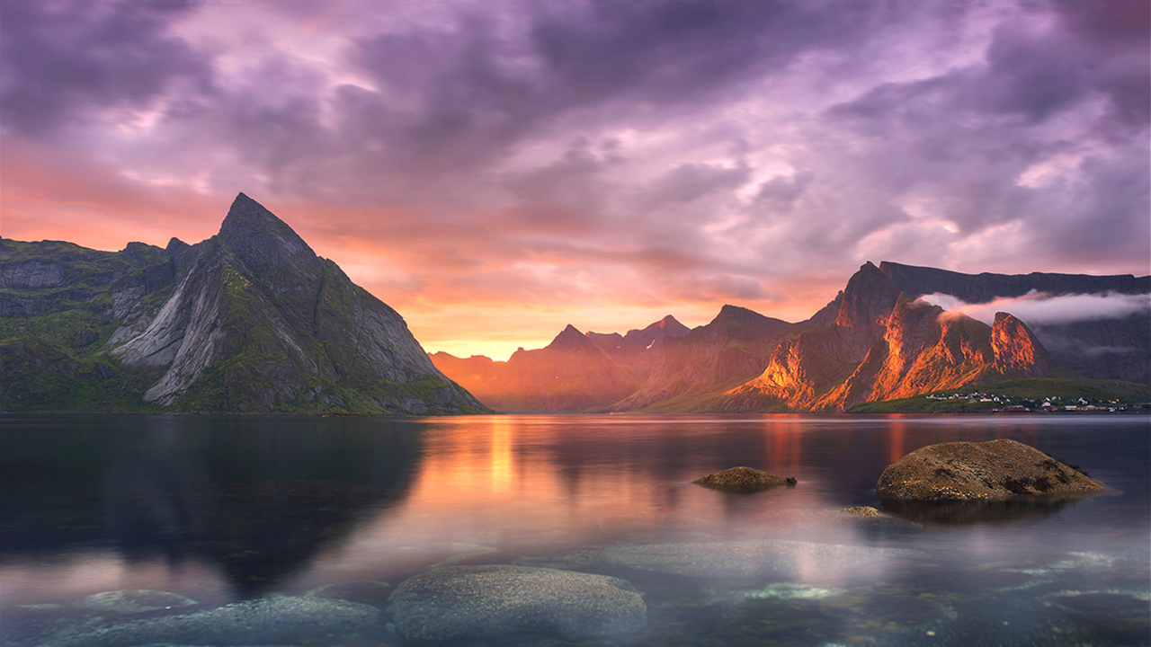 Montaña Marrón Cerca Del Cuerpo de Agua Bajo un Cielo Nublado Durante el Día. Wallpaper in 1280x720 Resolution