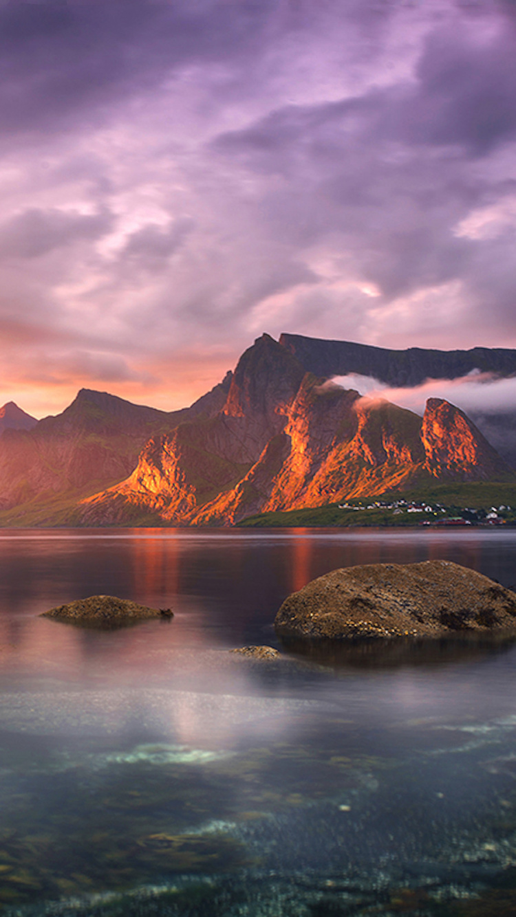 Montaña Marrón Cerca Del Cuerpo de Agua Bajo un Cielo Nublado Durante el Día. Wallpaper in 750x1334 Resolution