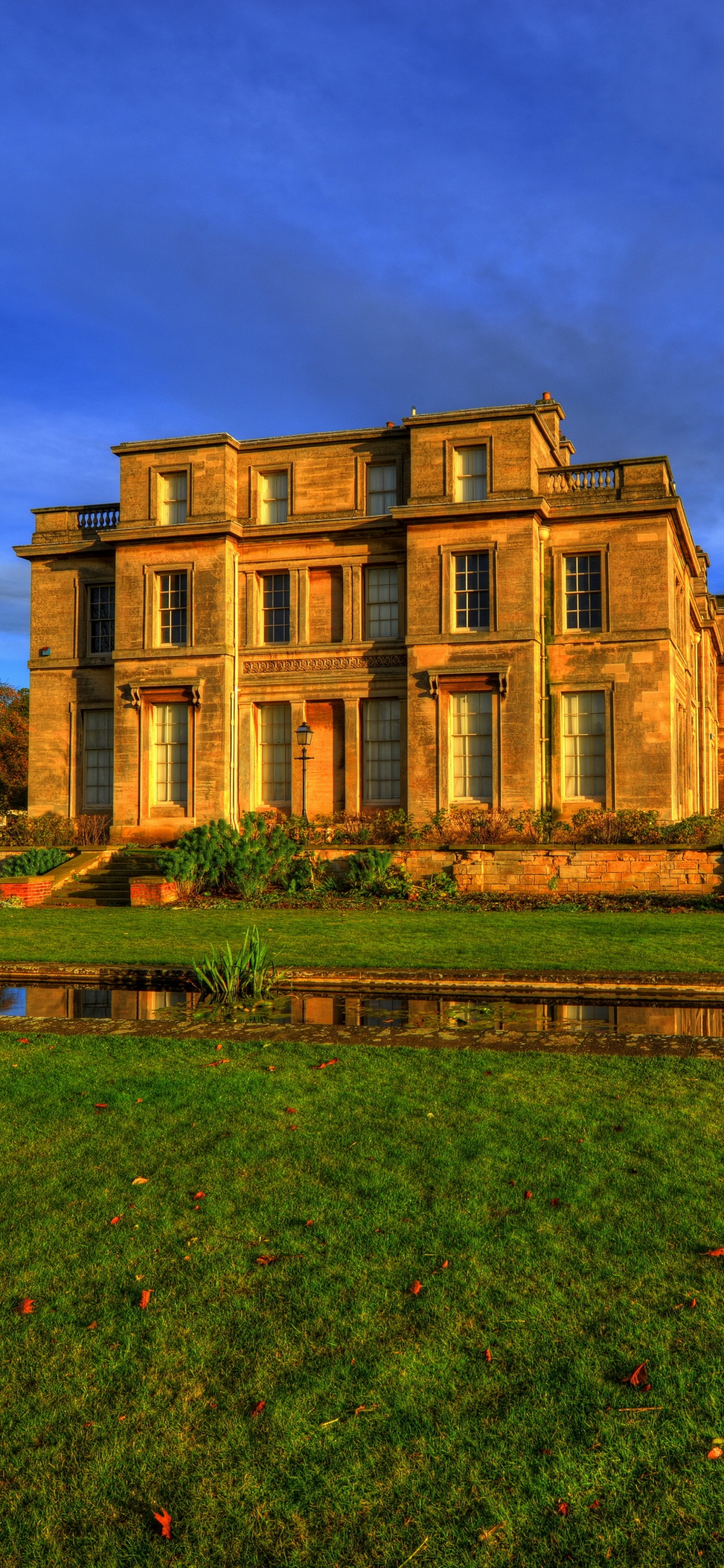 Braunes Betongebäude in Der Nähe Einer Grünen Wiese Unter Blauem Himmel Tagsüber During. Wallpaper in 1125x2436 Resolution