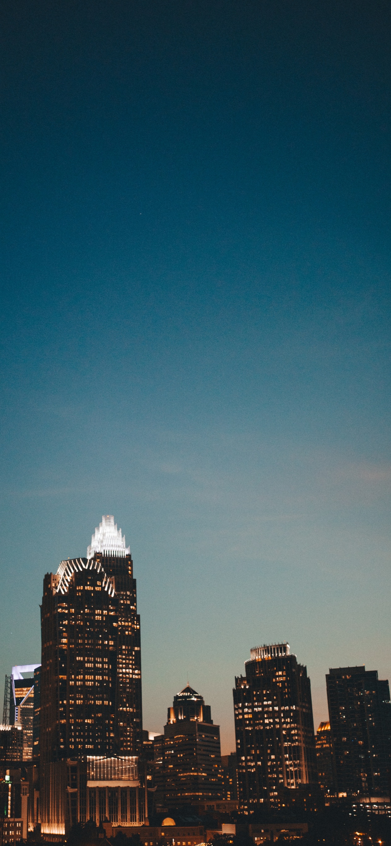 Skyline Der Stadt Unter Blauem Himmel Während Der Nacht. Wallpaper in 1242x2688 Resolution